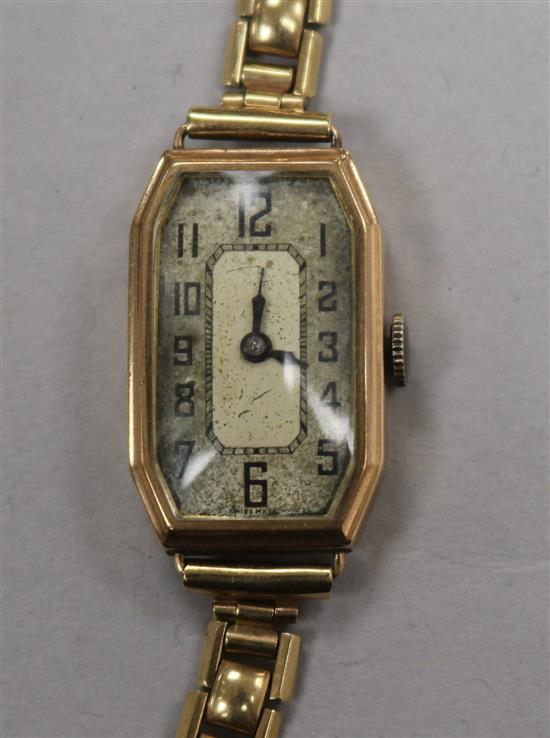 A ladys 1930s 9ct gold octagonal cased manual wind wrist watch, on a 9ct gold strap.